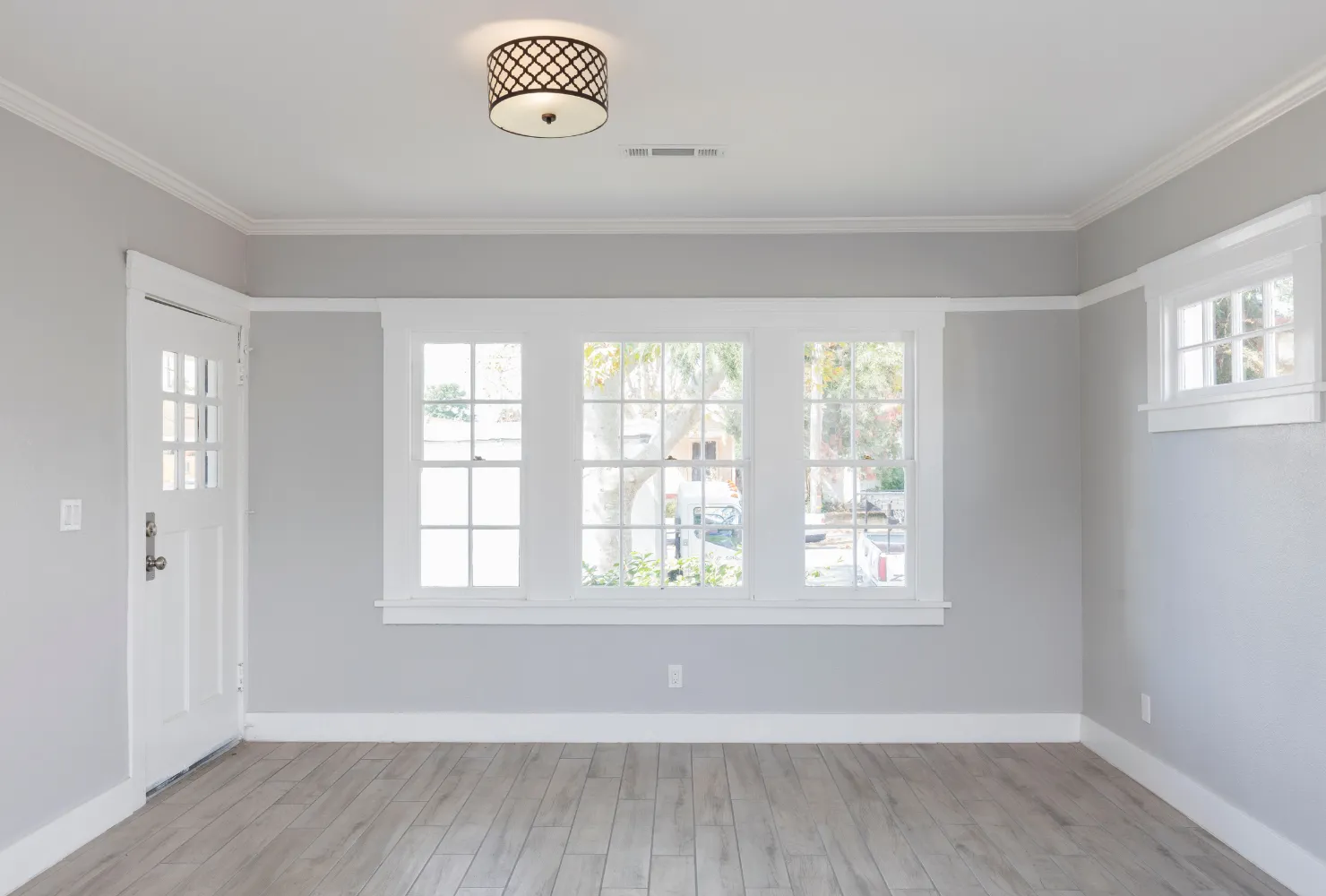 Residential interior painting project featuring modern gray walls with white trim and freshly painted living room