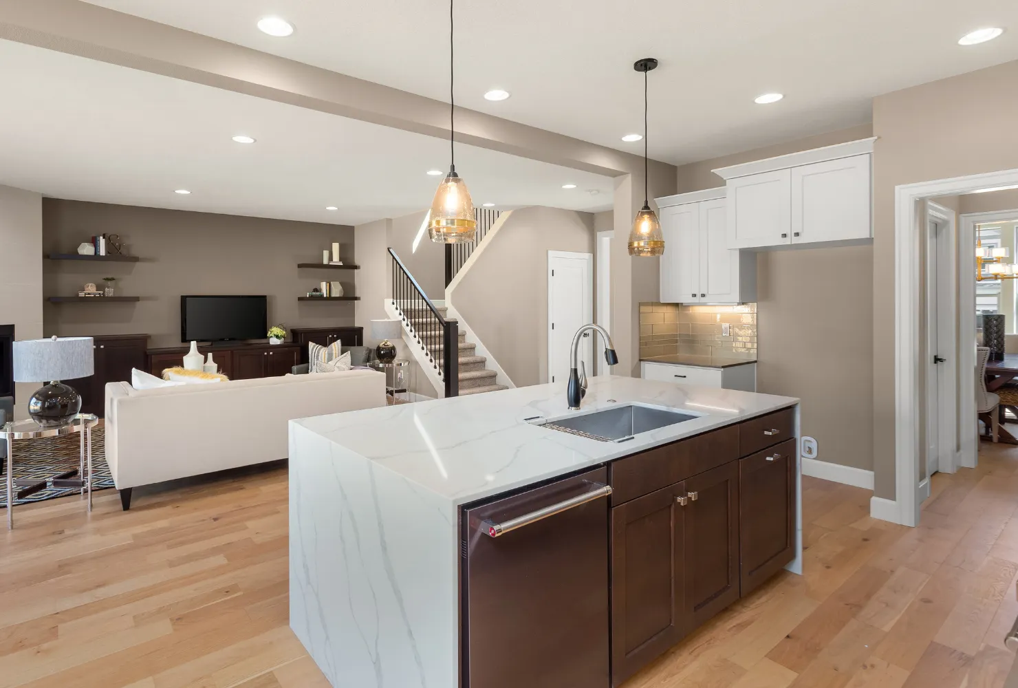 Two-tone cabinet painting project in an open-concept kitchen with freshly painted cabinets and modern finishes.